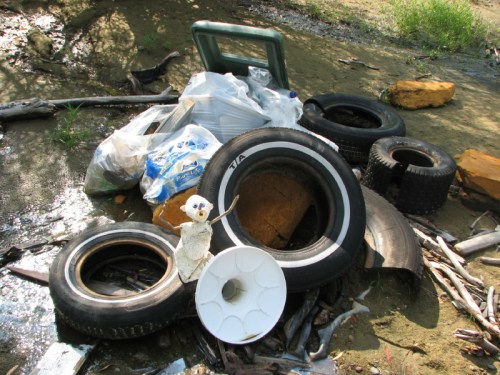 Kneeling figure with river sweep trash, 7/2010