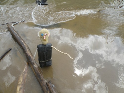 Styro-figure in black, waist deep in wet sand, July 2013